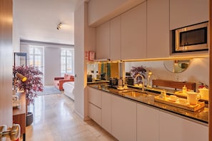 Une cuisine moderne dotée d’un îlot central, d’appareils électroménagers intégrés et d’une grande fenêtre.