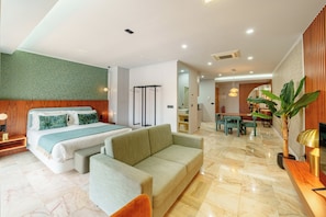 Ein modernes Hotelzimmer mit Bett, Sofa, Essbereich und einem Blumentopf.