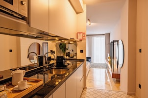 A modern kitchen with a central island, stainless steel appliances, and a view into the living area.