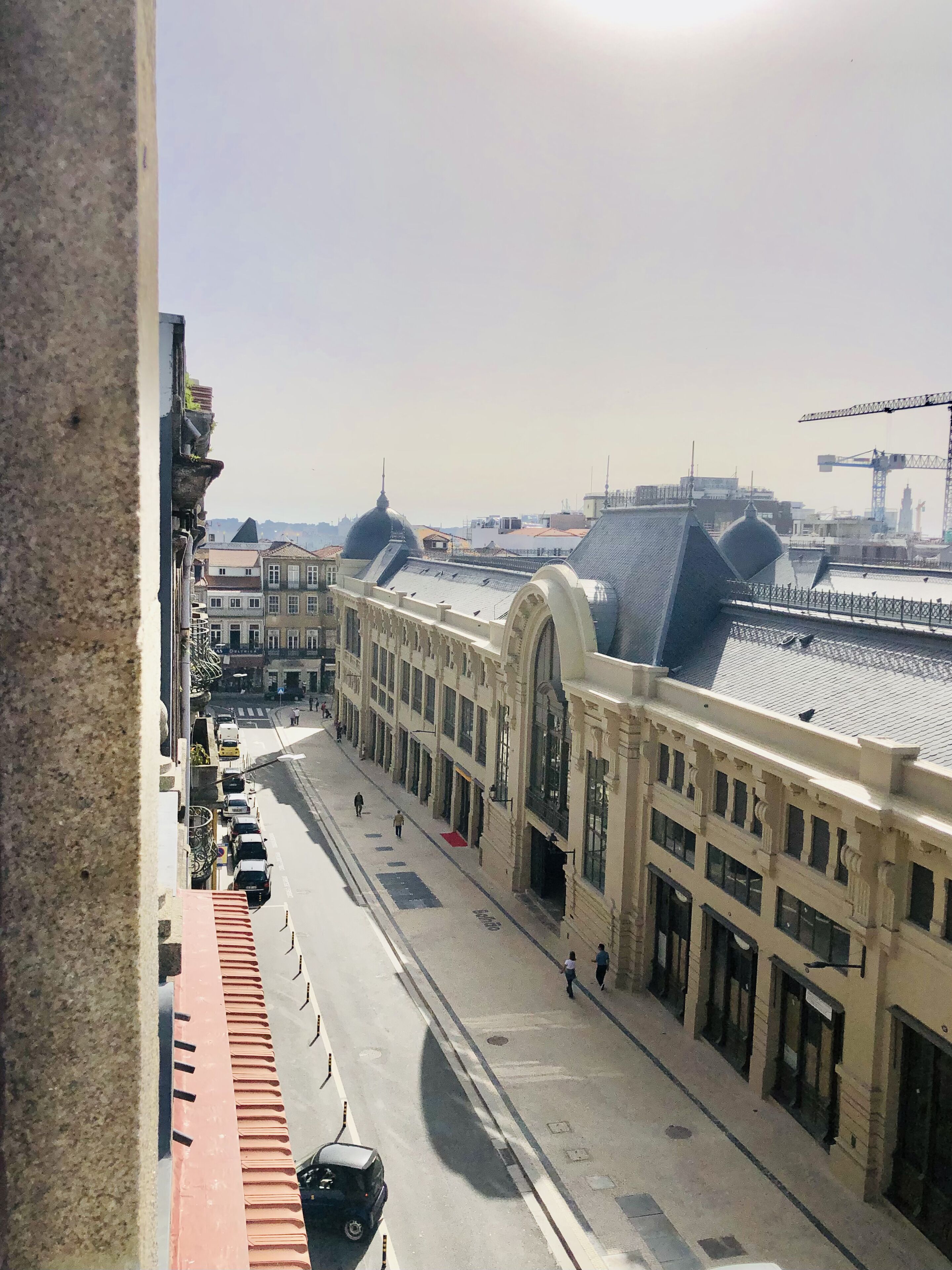 Une vue de rue avec une rangée de bâtiments caractérisés par de grandes fenêtres et un arc imposant.