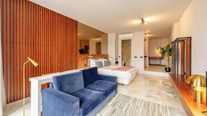 Ein modernes Wohnzimmer mit einem blauen Sofa, einem weißen Couchen und einer Holzwand.
