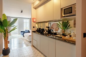 Une cuisine moderne équipée d’un four à micro-ondes, d’une machine à café et agrémentée de plantes en pot.
