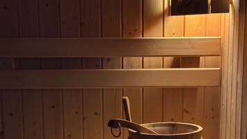 Un banco de sauna de madera con un cubo y una cuchara de madera.