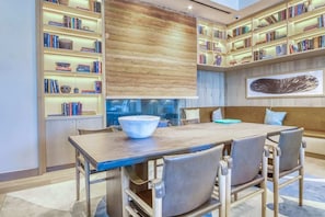 A modern library with bookshelves, a large bowl on the table, and a sofa. - Rainey St 1BR Luxury Condo • Rooftop Pool & Gym (Austin)