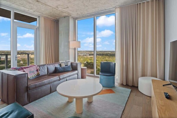 Una habitación moderna con un sofá, una mesa redonda, una silla y un televisor.