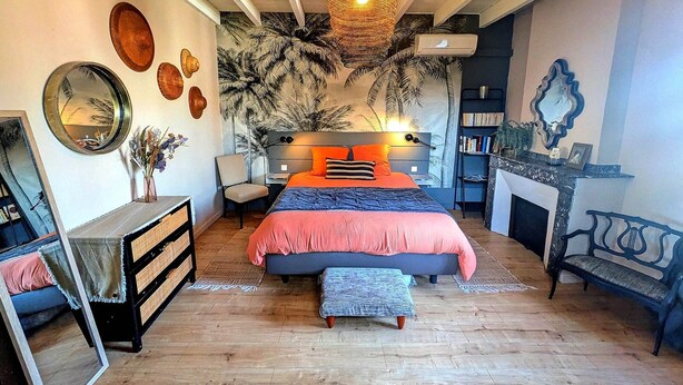 A bedroom with a bed, bedside tables, a mirror, a dresser, a bench, a fireplace, and a bookshelf. - Comfortable 50 m2 apartment in Marssac sur Tarn, between Gaillac and Albi (Marssac-sur-Tarn)