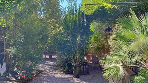 A garden with a gravel path, potted plants, and a birdcage. - Comfortable 50 m2 apartment in Marssac sur Tarn, between Gaillac and Albi (Marssac-sur-Tarn)