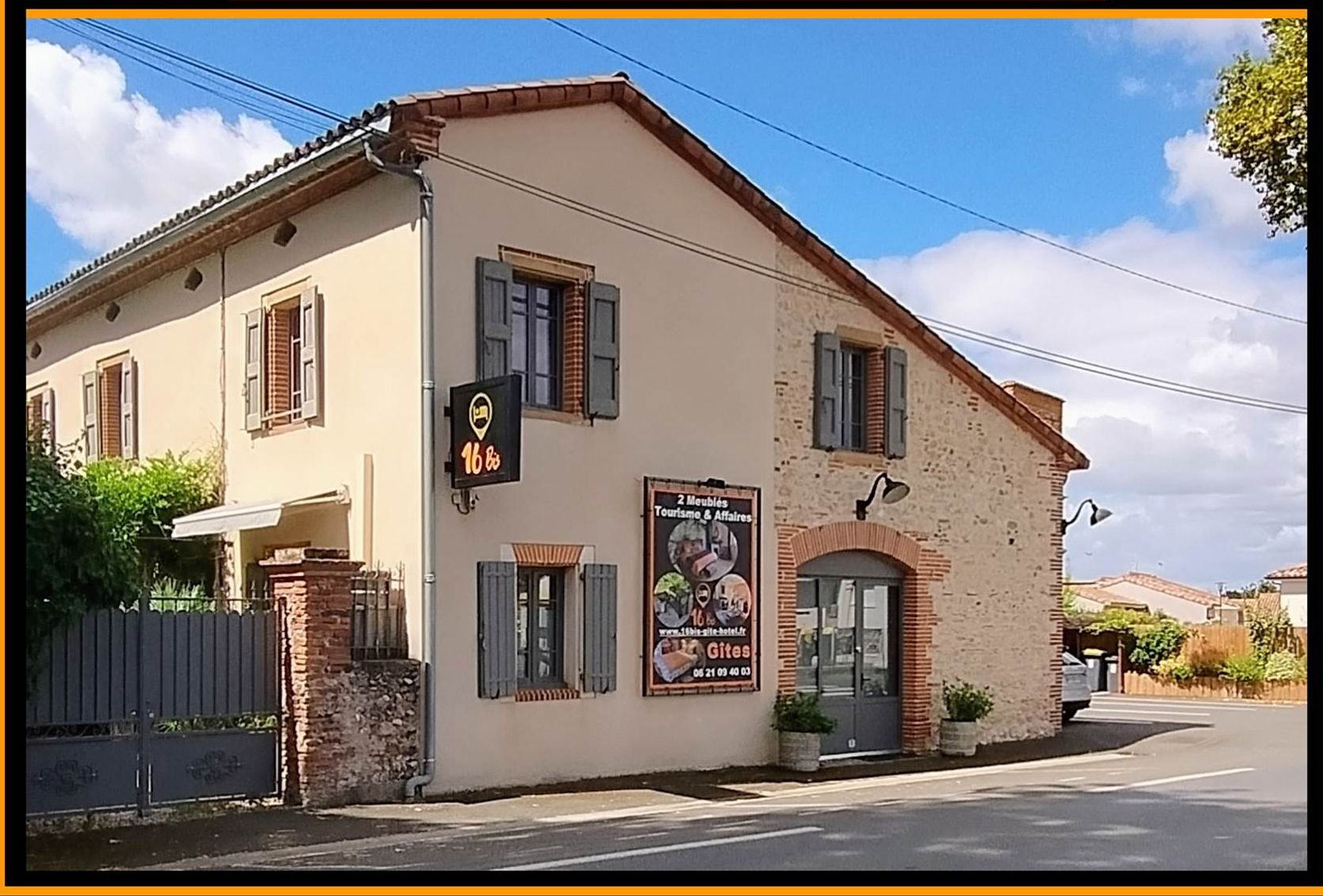 A two-story building with a beige facade, a signboard advertising a restaurant, and a visible entrance.