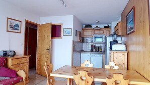 Een kleine keuken met houten kastjes, een magnetron, een broodrooster en een vaatwasser.