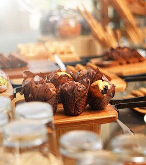 Variedad de productos horneados, como muffins y pasteles, expuestos en tablas de madera.