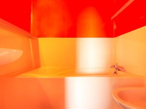 Un baño con bañera, lavabo y espejo.