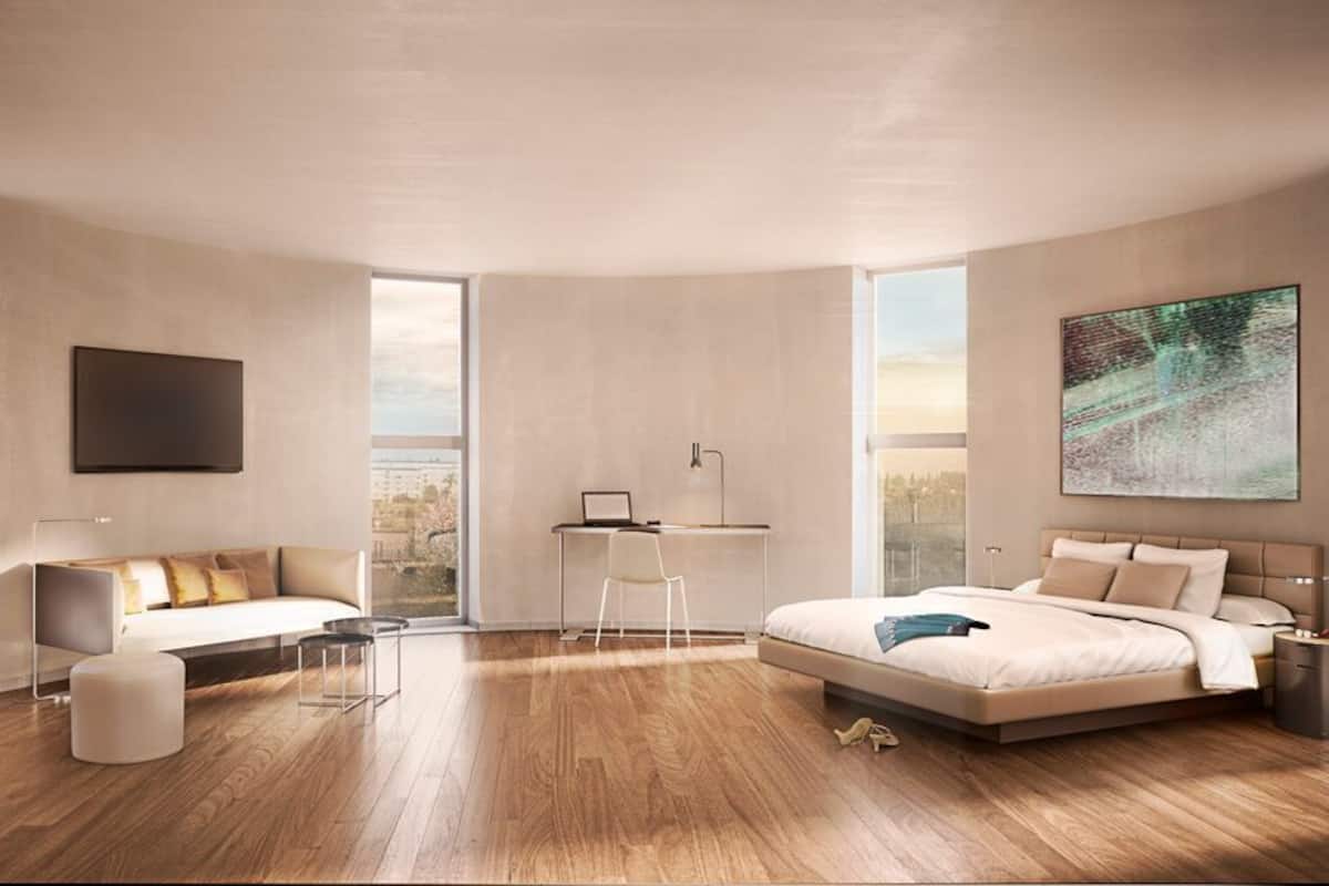 Een moderne slaapkamer met een bed, een bureau en een bank.