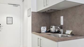 Een moderne keuken met witte kasten, een roestvrijstalen spoelbak en een ingebouwde toaster.