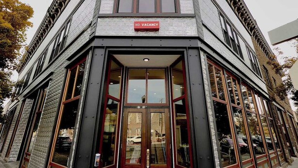A corner building with a "NO VACANCY" sign, a double door entrance, and a "Litch Hotel" sign at the bottom.