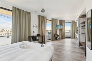 Habitación de hotel con cama, escritorio, silla y televisión.