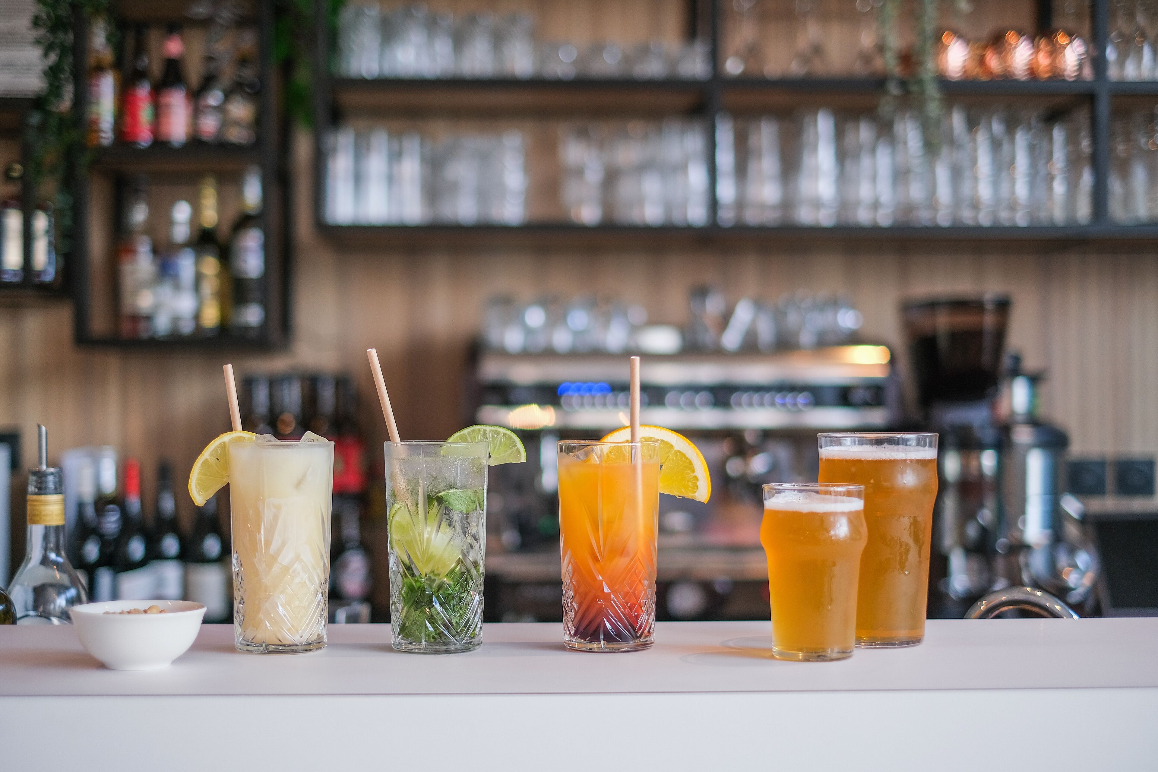Un bar avec diverses boissons et bouteilles en arrière-plan.