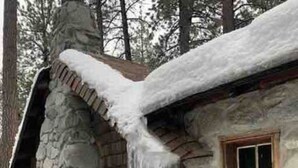 Una cabaña de piedra con una ventana y estalactitas colgando del tejado.