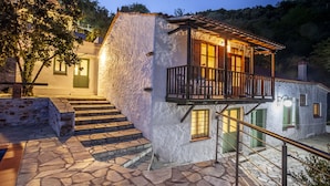 A stone staircase leading to a white building with a balcony.