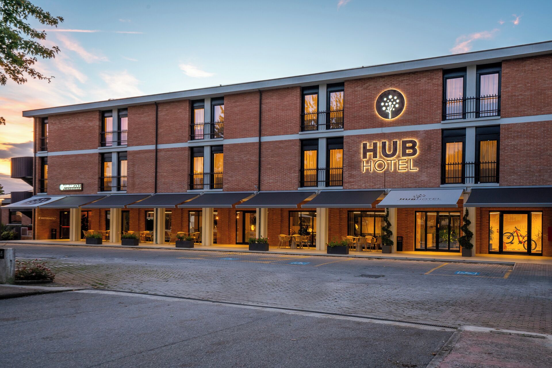 HUB HOTEL con facciata in mattoni, diversi balconi e zone salotto all'aperto.