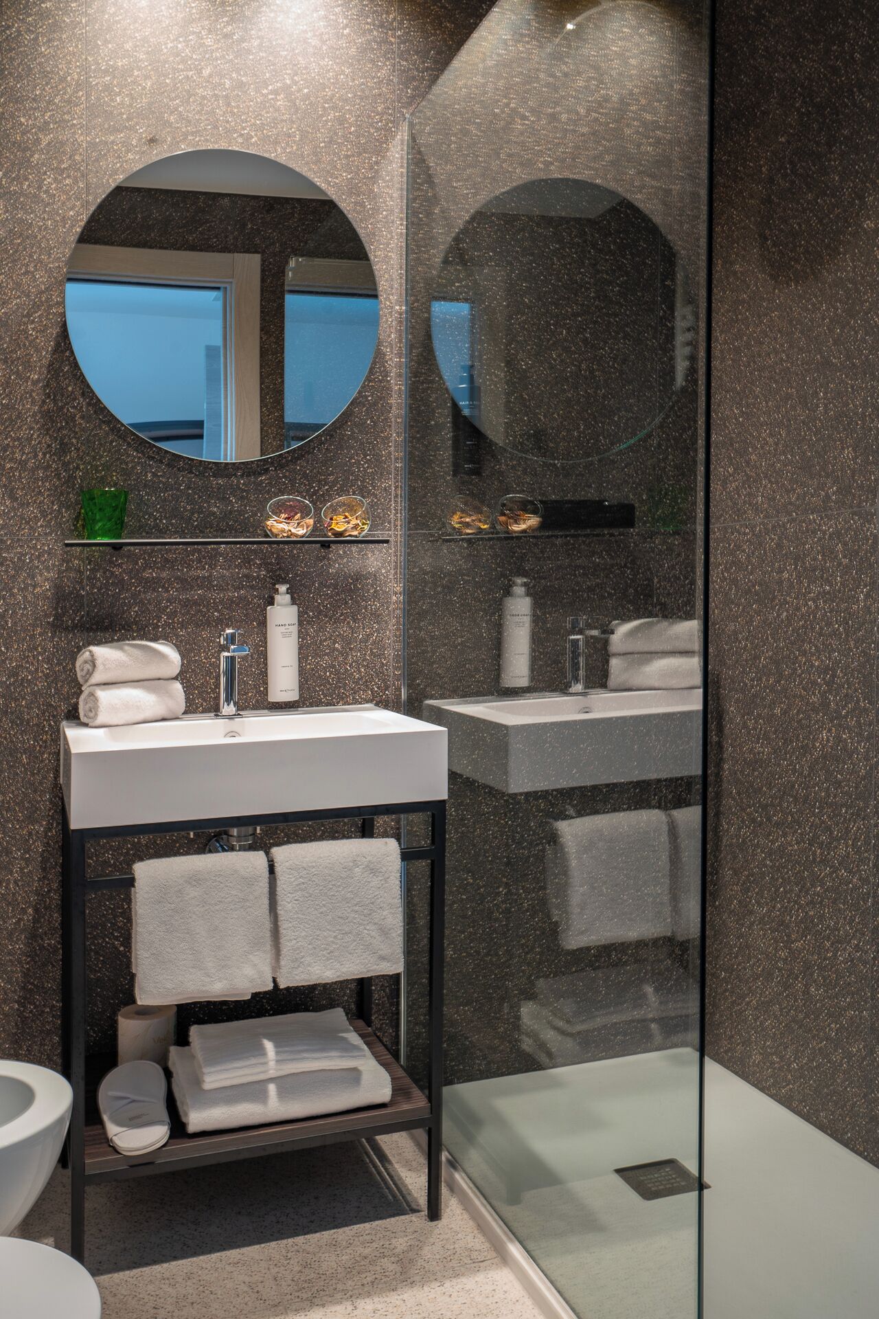 Un baño moderno con un espejo grande, dos lavamanos y un box de ducha de vidrio.