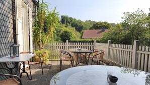 A patio with a round table, chairs, and a lantern. - Dreamholiday - Stylish large vacation home with garden for 20+ people (Mittelhof)