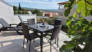 Ein Balkon mit Tisch, Stühlen und Blick auf die Stadt.