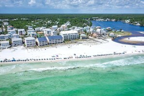 A coastal resort with beachfront properties, a sandy beach, and a clear view of the ocean.
