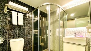 A modern bathroom with a glass-enclosed shower, a white toilet, and a vanity with a mirror. - HUB HOTEL XIMEN XINING INN (Taipei)