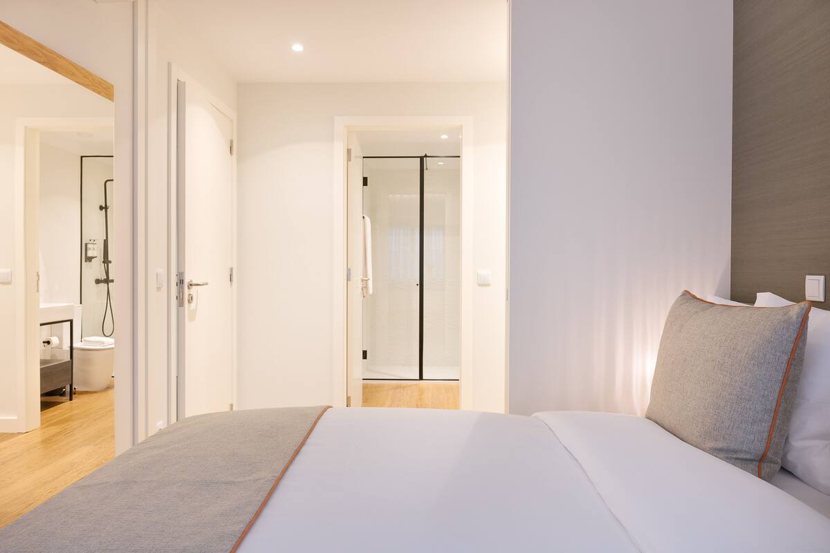 Een moderne hotelkamer met een groot bed, een douche en een zichtbare badkamer.