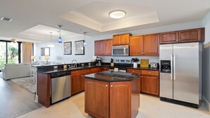 A modern kitchen with wooden cabinets, stainless steel appliances, and a central island. - Stay 2 nights and get an extra night free! - Unit 116 - Exceptions Apply (Dauphin Island)