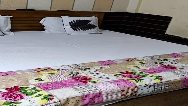 Ein Bett mit einer Blumensteckdecke und einem Holz-Kopfteil.