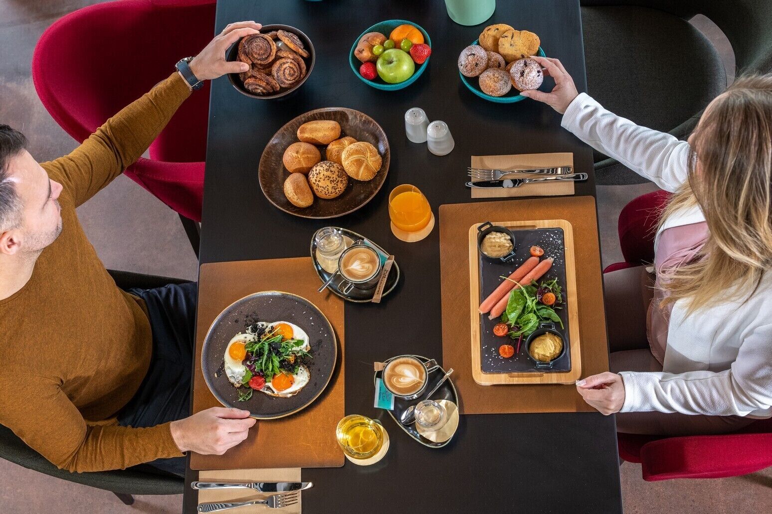 Un tavolo imbandito con diversi cibi e bevande, tra cui pasticcini, frutta e un'insalata.