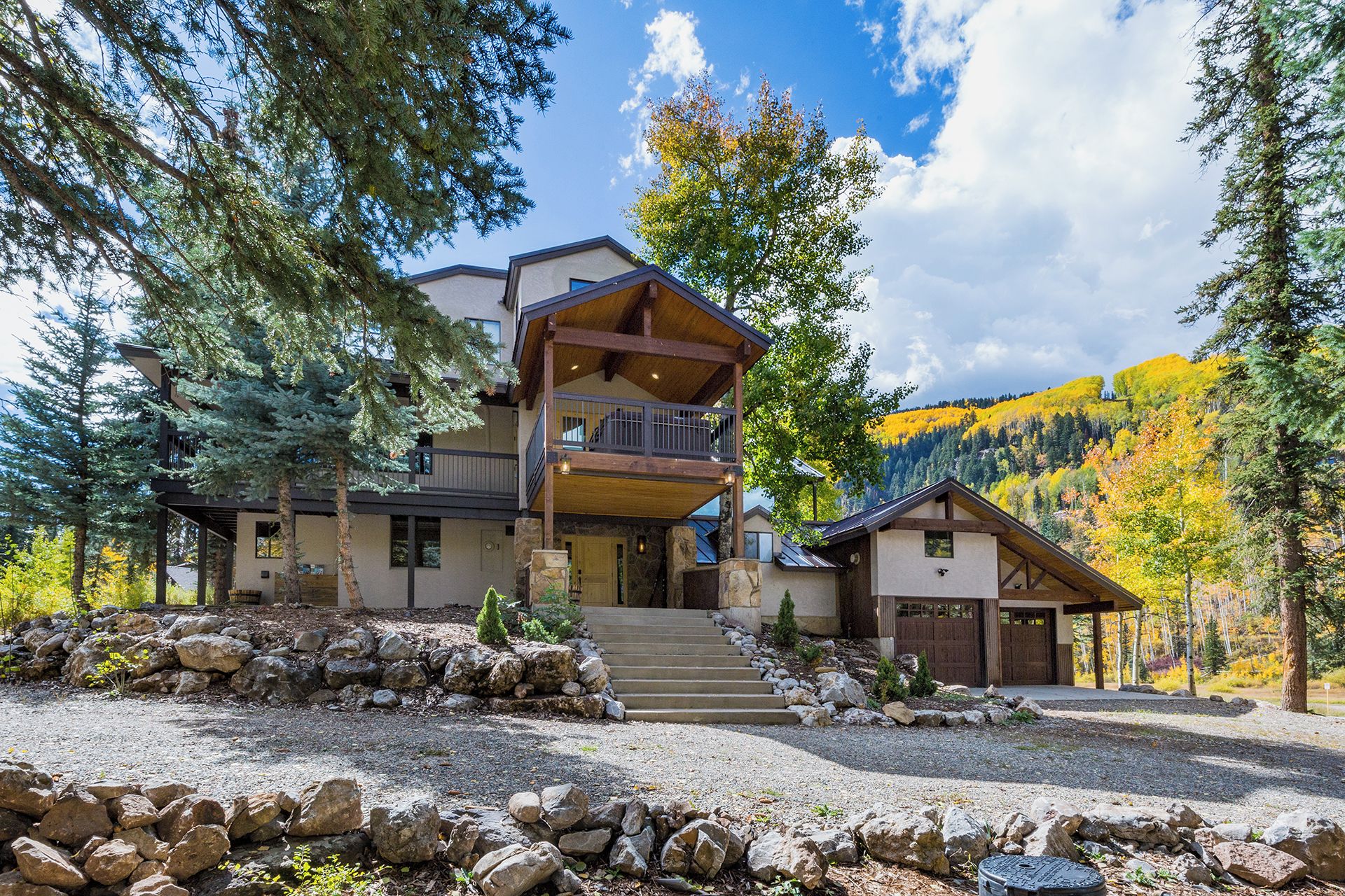A two-story lodge with a stone foundation, a balcony, and a garage.