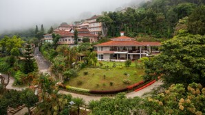 A residential area with houses surrounded by lush greenery and a well-maintained garden. - amã Stays & Trails Arcadia, Coorg (Virajpet)