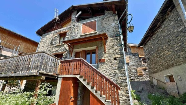 A stone building with a wooden staircase, a balcony, and a small window. - Terrace, fireplace or stove, tv, ski locker, 30m², Les Menuires (Saint-Martin-de-Belleville)