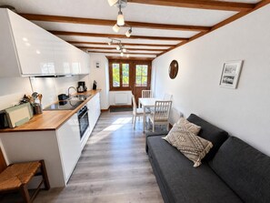 A compact living space with a kitchenette, a dining area, and a sofa. - Terrace, fireplace or stove, tv, ski locker, 30m², Les Menuires (Saint-Martin-de-Belleville)