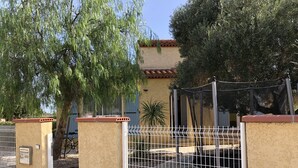 A gated area with a beige wall, a metal gate, and a tree. - 5'du Barcares, lovely air-conditioned villa with heated pool (ST LAURENT DE LA SALANQUE)