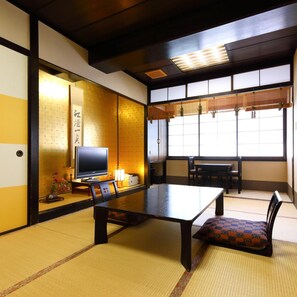 A traditional Japanese room with tatami flooring, a low table, and a television. - Ureshino Onsen Takasago (Ureshino)