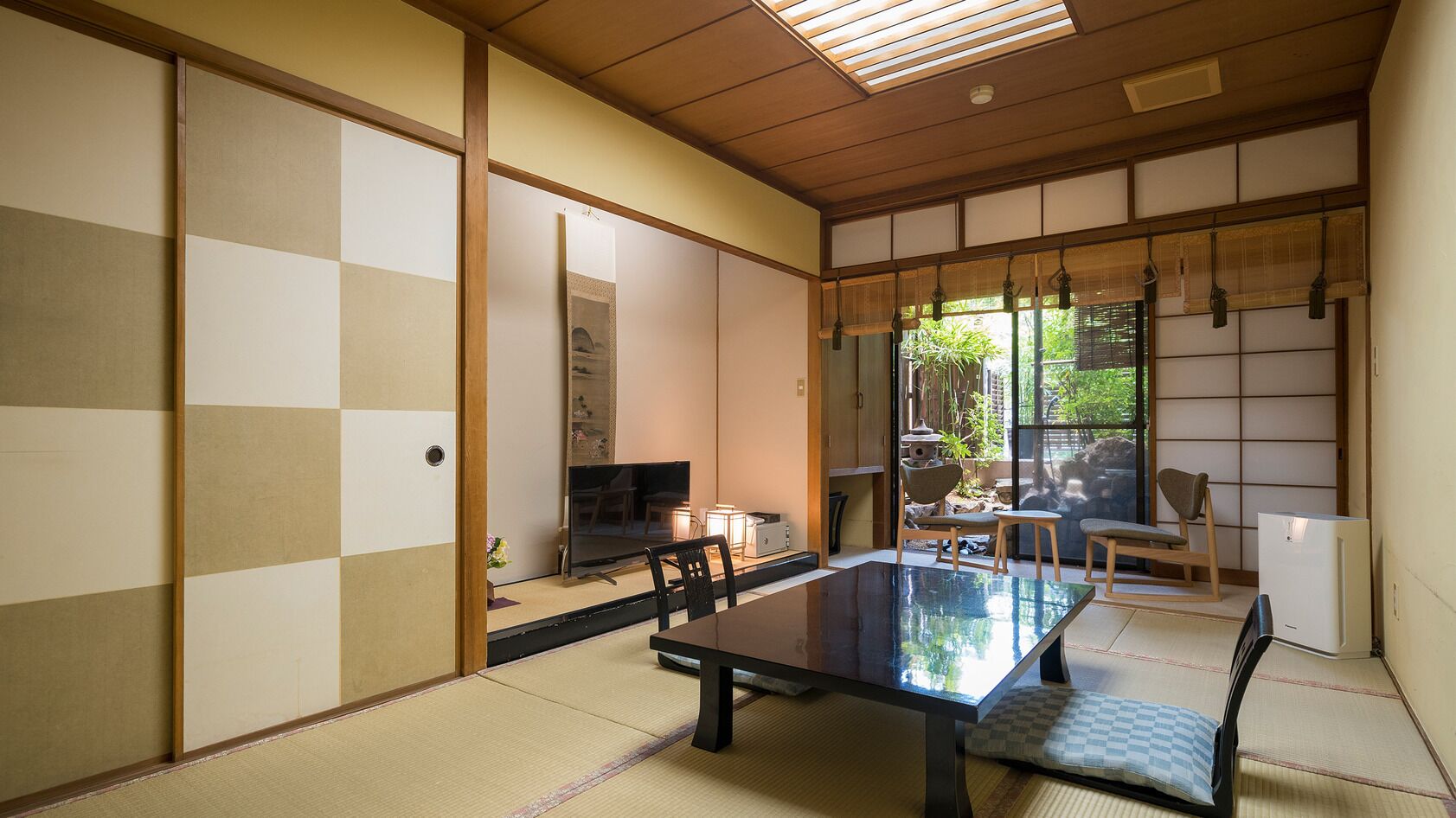 A traditional Japanese room with tatami flooring, a low table, and sliding doors.