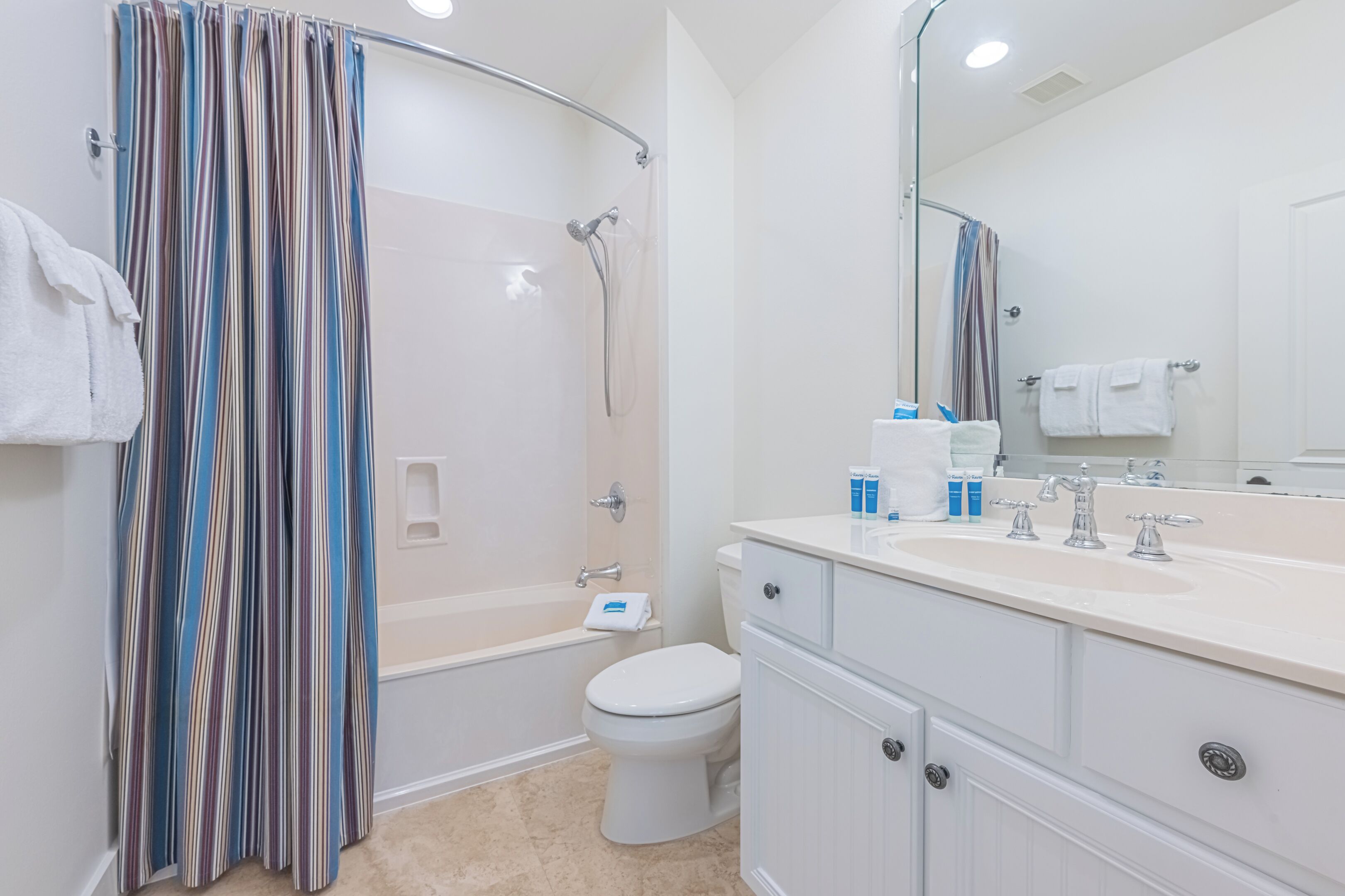 A modern bathroom with a shower, toilet, and vanity.