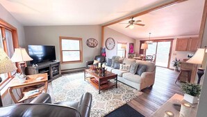A spacious living room with a television, sofa, coffee table, and a fireplace. - Edgewater Retreat on Beautiful Soo Lake! (Phillips)