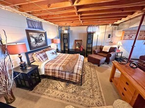 A cozy bedroom with a bed, a sofa, a wooden dresser, and a rug. - Edgewater Retreat on Beautiful Soo Lake! (Phillips)