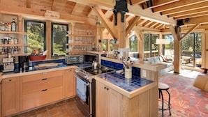 A spacious kitchen with wooden beams, a large island, and a view of the outdoors. - Amazing Architecture - Views all around VH#113 by Bear Valley Vacation Rentals (Arnold)