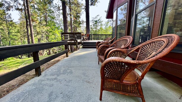 A wooden deck with wicker chairs, a wooden bench, and a table. - In the Pines, Cozy Retreat with Amazing Views (Idyllwild)