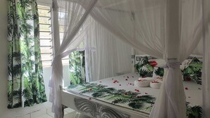 A room with a bed under a canopy, a window with curtains, and a tiled floor. - Stay.Plus Nyumba Tulivu Watamu (Watamu)