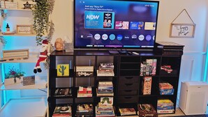 Una sala de estar con un televisor sobre un mueble bajo, rodeada de estanterías llenas de libros y adornos.