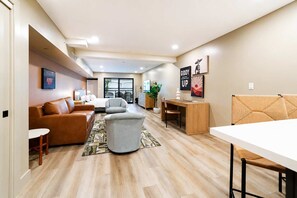 A modern living room with a sofa, armchairs, a dining table, and a kitchen area in the background. - NEW|Luxe Mesquite Studio Suite @ Cedara| Old Town (Scottsdale)