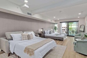 Une chambre moderne avec un grand lit, un canapé et un balcon offrant une belle vue.