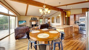 Un salón espacioso con chimenea, un comedor con mesa y sillas de madera, y una cocina con electrodomésticos modernos.
