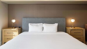 A hotel room with a large bed, two bedside tables, and two wall-mounted lamps. - NEW|Luxe Cypress Suite @ Cedara |Heart of Old Town (Scottsdale)